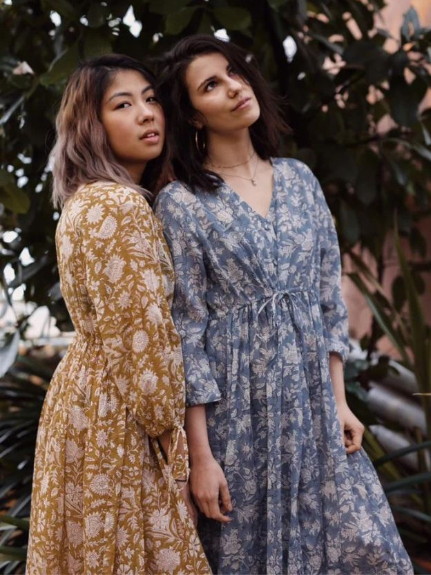 Two women outside wearing Nest Factory summer dresses in blue and yellow color