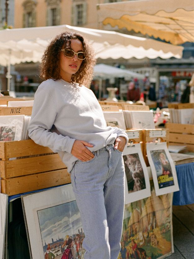 woman wearing mud jeans light denim loose fit jeans at a market on a sunny day