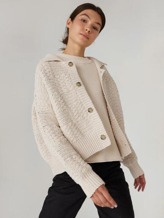 A woman wearing a natural white cardigan by The Knotty Ones