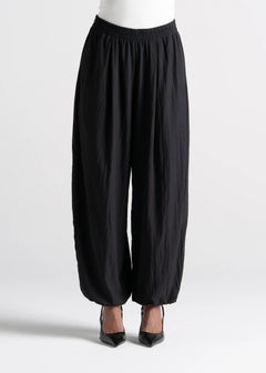 Black wide-leg pants worn by a person on a white background