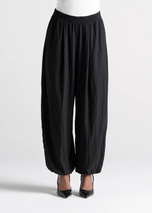 Black wide-leg pants worn by a person on a white background