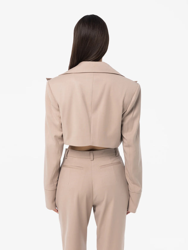 Person wearing a beige suit on a white background