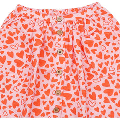 Pink shorts with orange heart pattern and button details on a white background