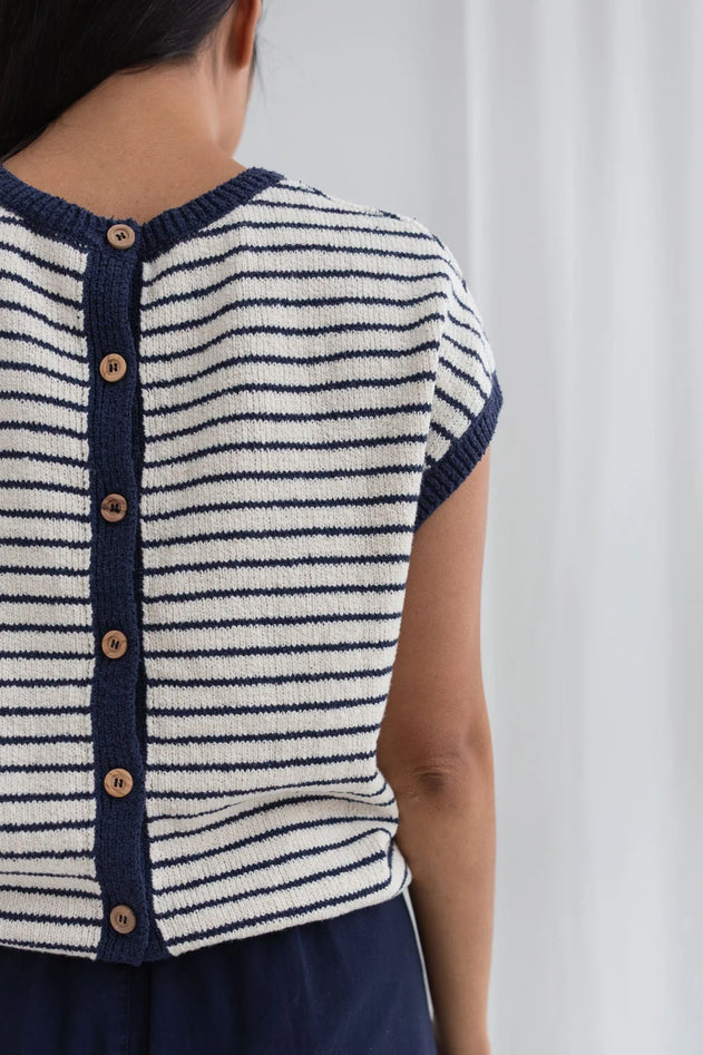 Navy and white striped shirt with button details on a plain background