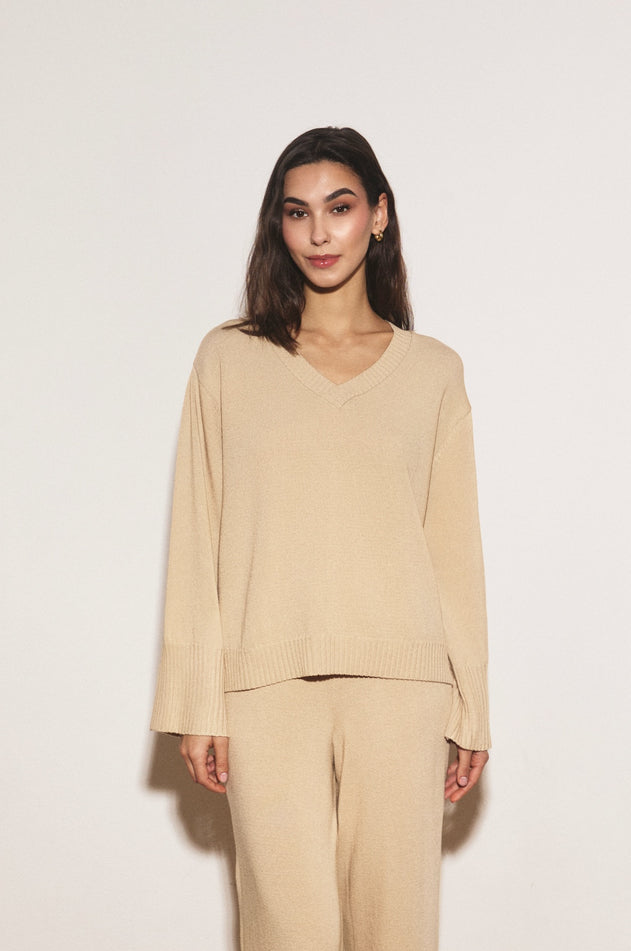 Woman wearing a beige outfit against a white background