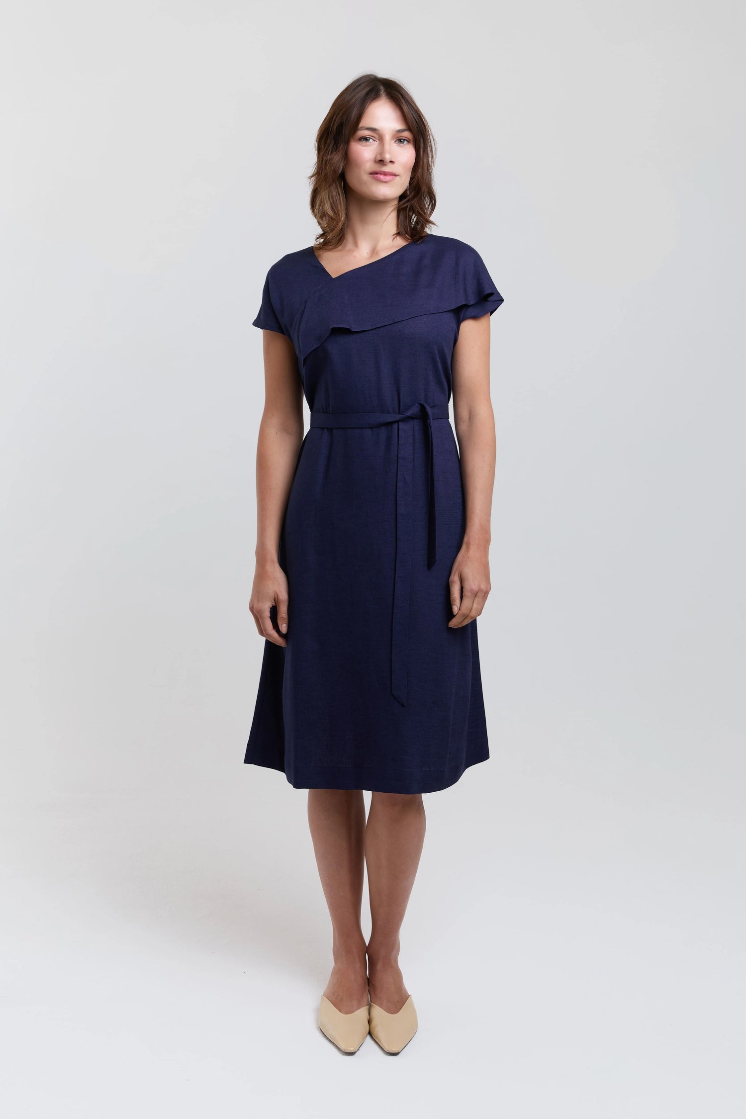 Woman wearing a navy blue dress on a white background