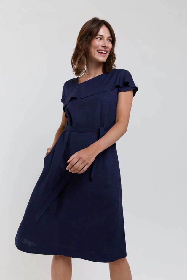 Woman wearing a navy blue dress against a white background