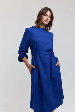Woman wearing a blue dress against a plain background