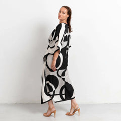 Woman wearing a black and white patterned dress on a plain background