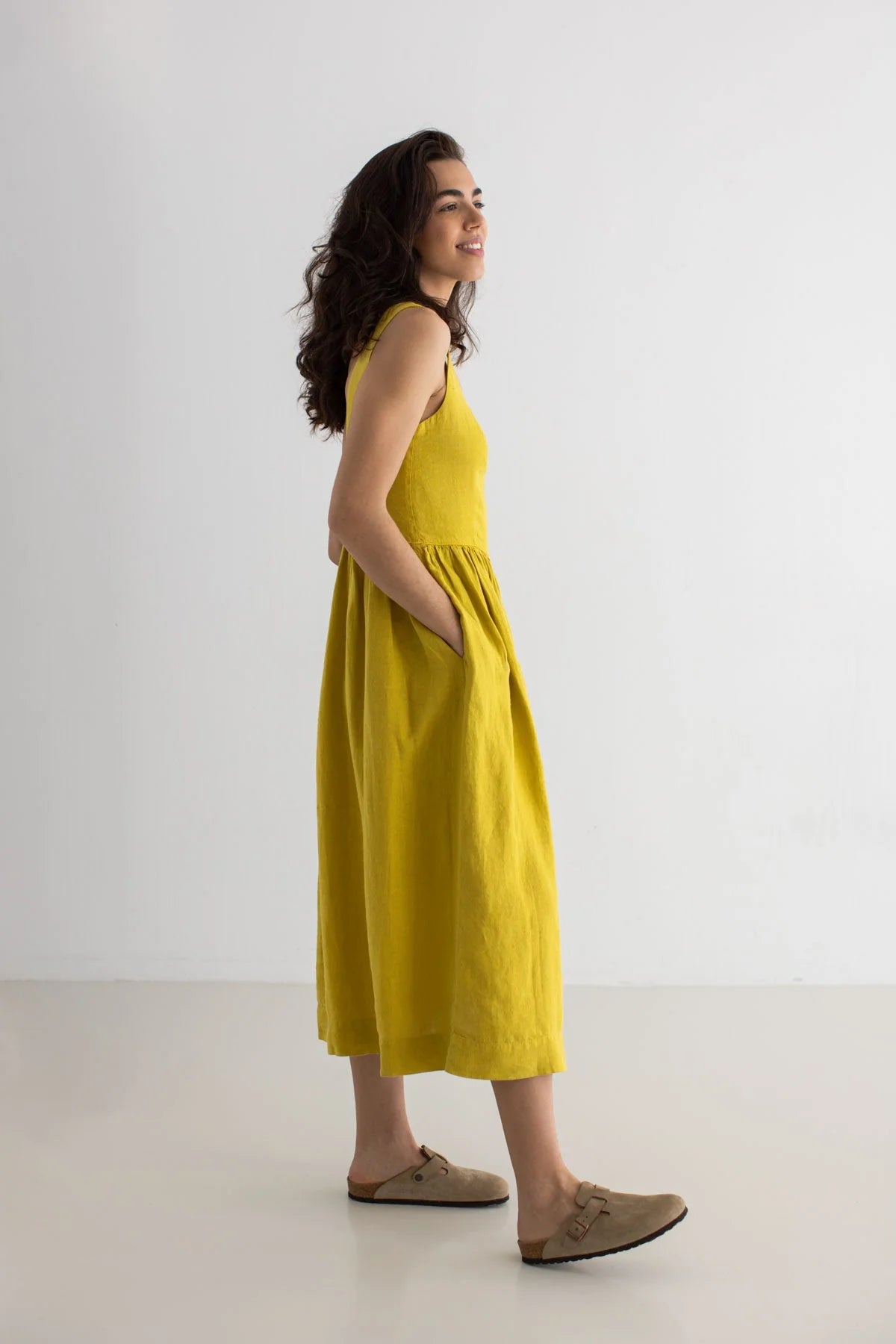 Woman wearing a yellow dress standing against a white background