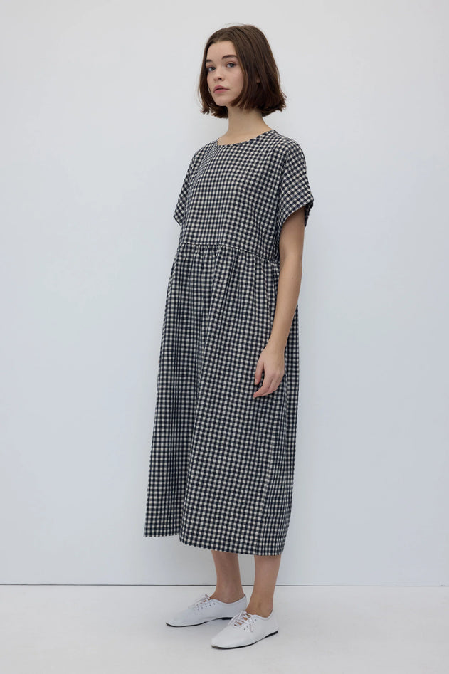 Woman wearing a black and white checkered dress against a white background
