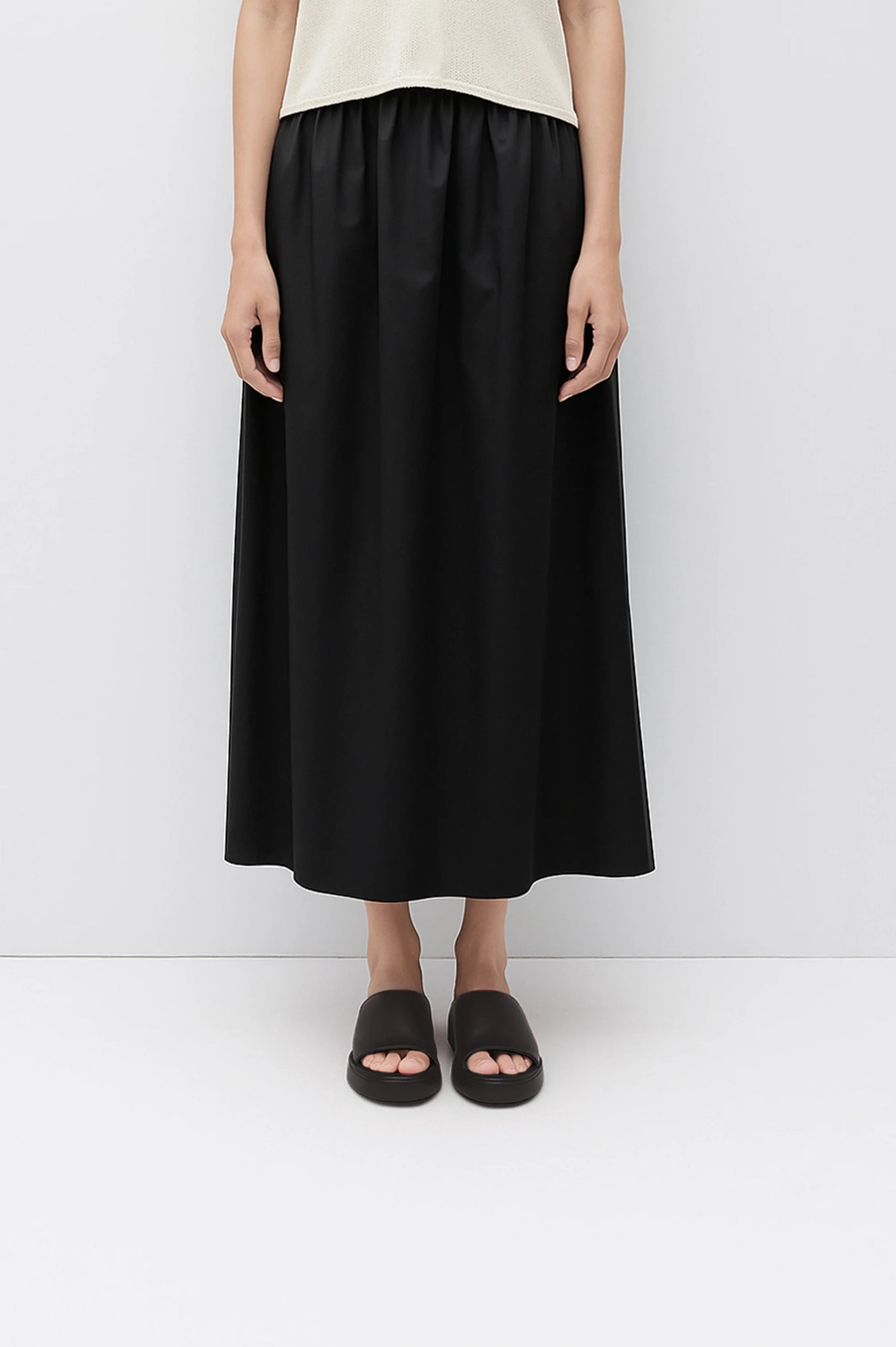 Person wearing a black skirt on a white background