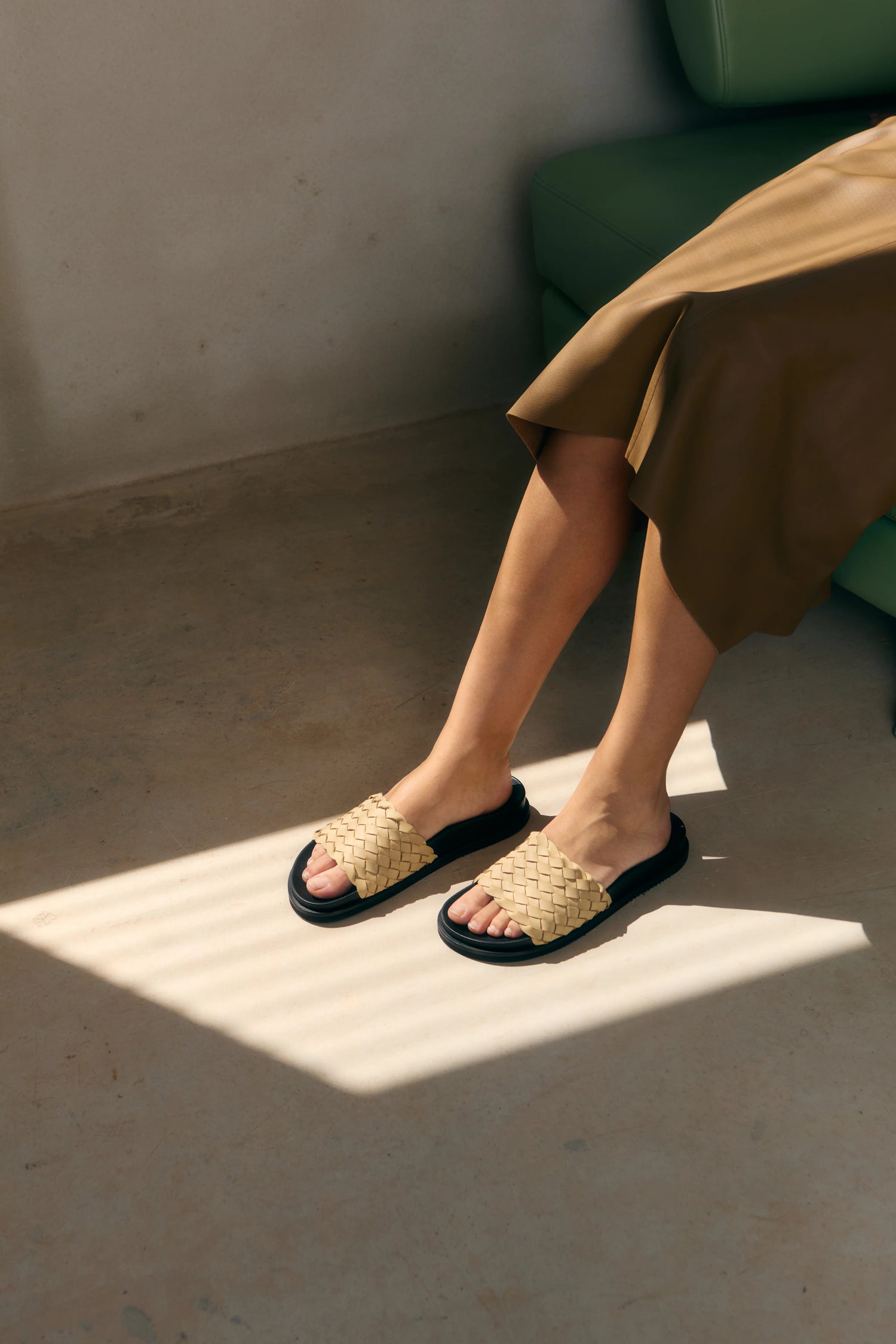 Person wearing woven sandals on a sunlit floor