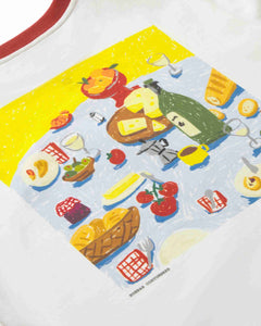 A close-up of a white garment featuring a colorful graphic print of a picnic scene with bread, cheese, tomatoes, wine, and other food items. The brand name 'MORRIS CONTORISH' is printed near the bottom of the graphic.