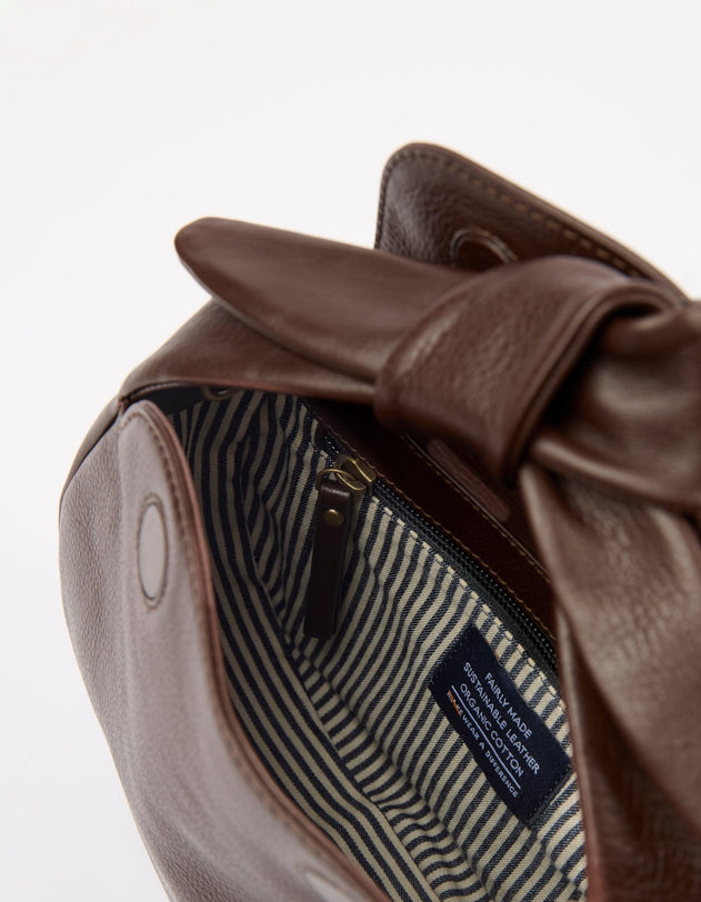 Brown leather bag with a bow detail on a white background