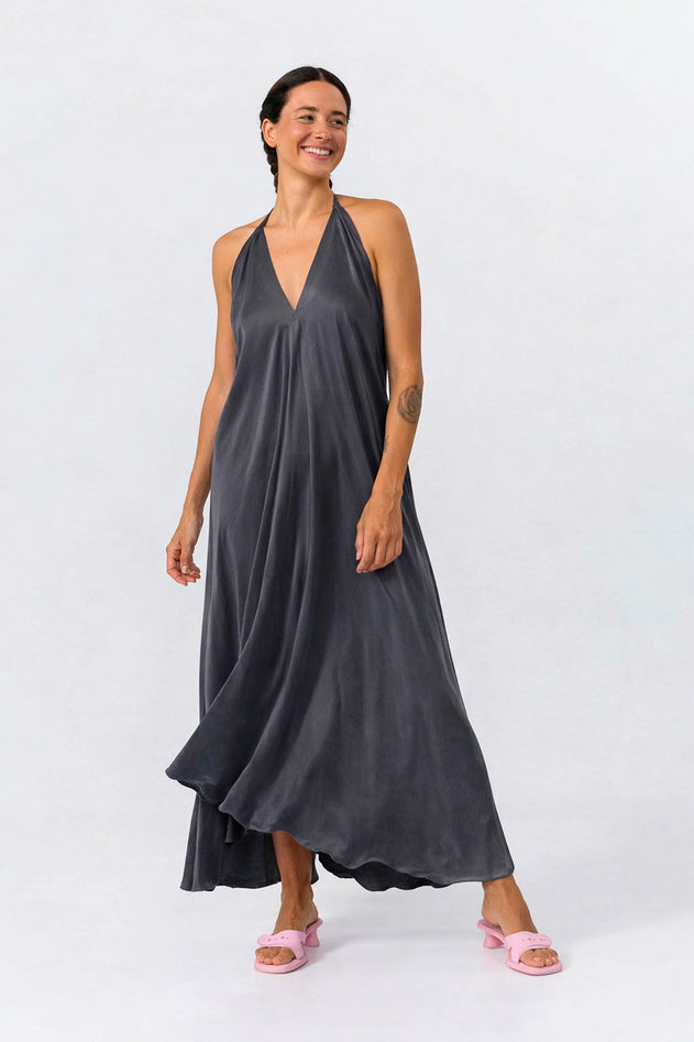 Woman wearing a dark gray halter neck dress on a white background